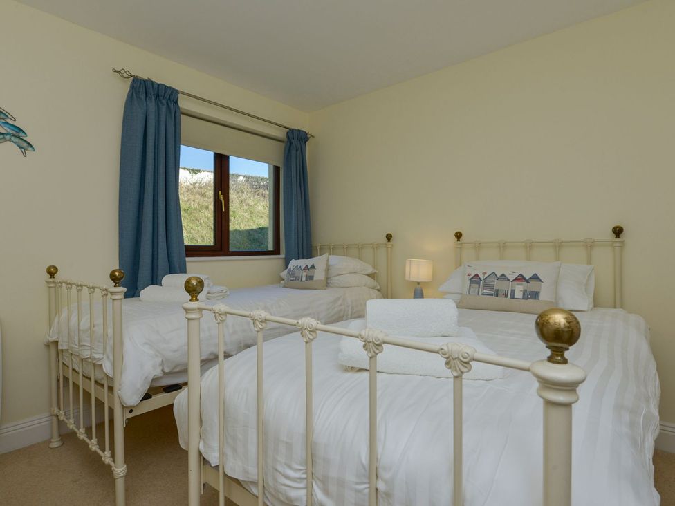 A bedroom with two beds and a window at Apartment 12, Burgh Island Causeway, Bigbury-On-Sea