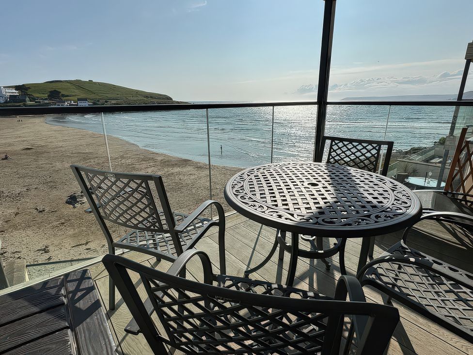 An outdoor seating area with a table and chairs overlooking the beach at 12 Burgh Island Causeway Bigbury-On-Sea