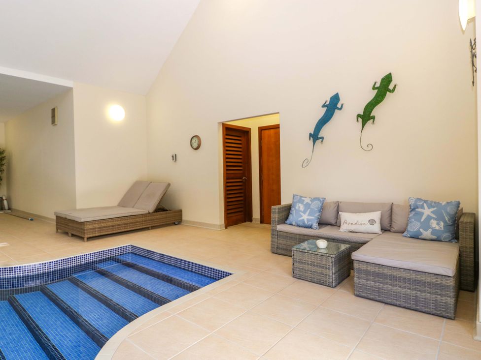 A living room with a jacuzzi and seating area at Heathcliffe House Caslteton near Cardiff