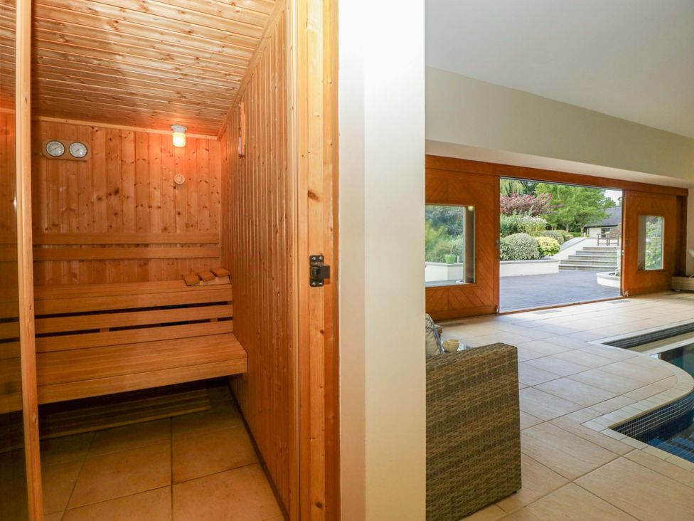 A sauna and indoor seating area with a pool at Heathcliffe House in Castleton near Cardiff