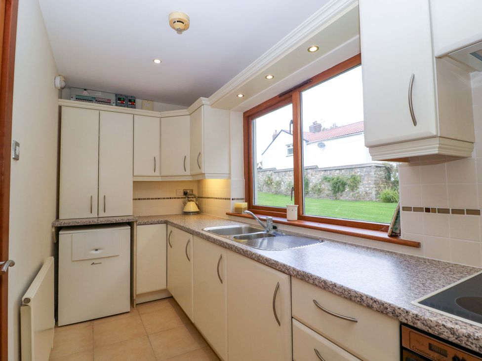 A kitchen with cabinets and a sink at Heathcliffe House in Castleton near Cardiff