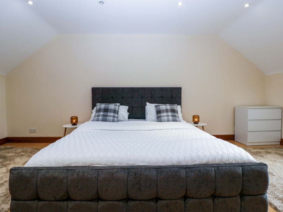 A bedroom with a bed and dresser at Heathcliffe House in Caslteton near Cardiff