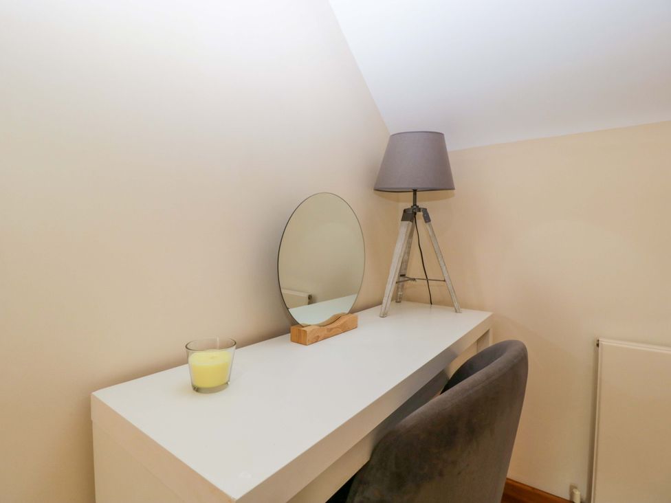 A desk with a mirror and lamp at Heathcliffe House Caslteton near Cardiff