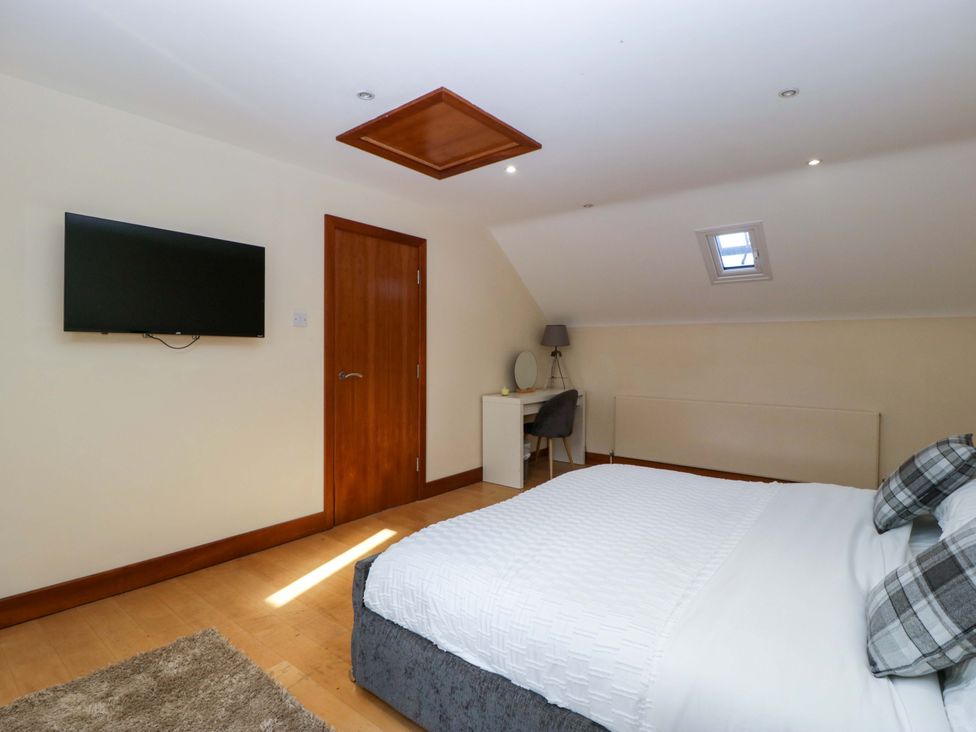A bedroom with a bed and a television at Heathcliffe House in Castleton near Cardiff