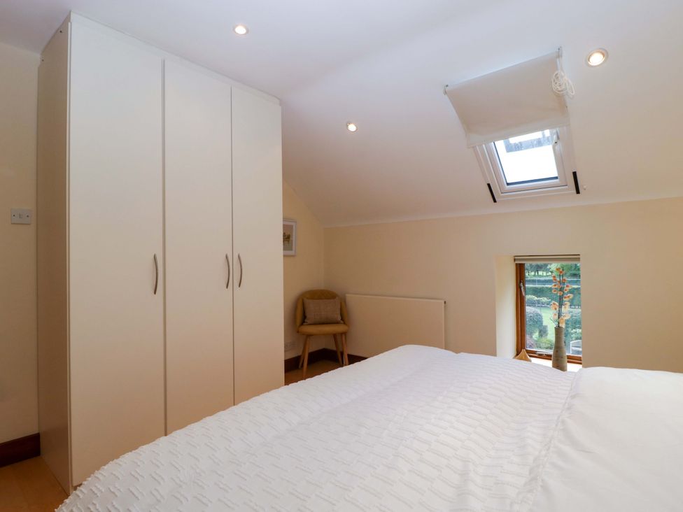 A bedroom featuring a wardrobe, bed, chair, and window at Heathcliffe House Castleton near Cardiff