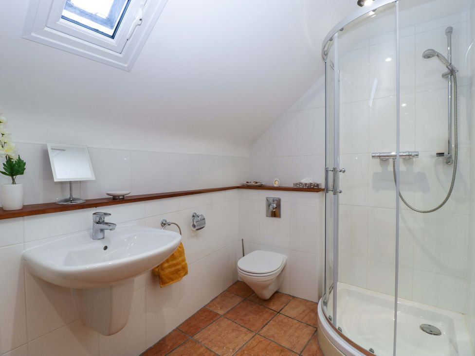 A bathroom with a shower, toilet, and wash basin at Heathcliffe House in Castleton near Cardiff