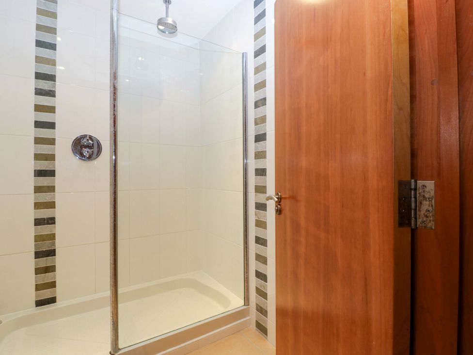 A shower with glass door in a bathroom at Heathcliffe House Caslteton near Cardiff