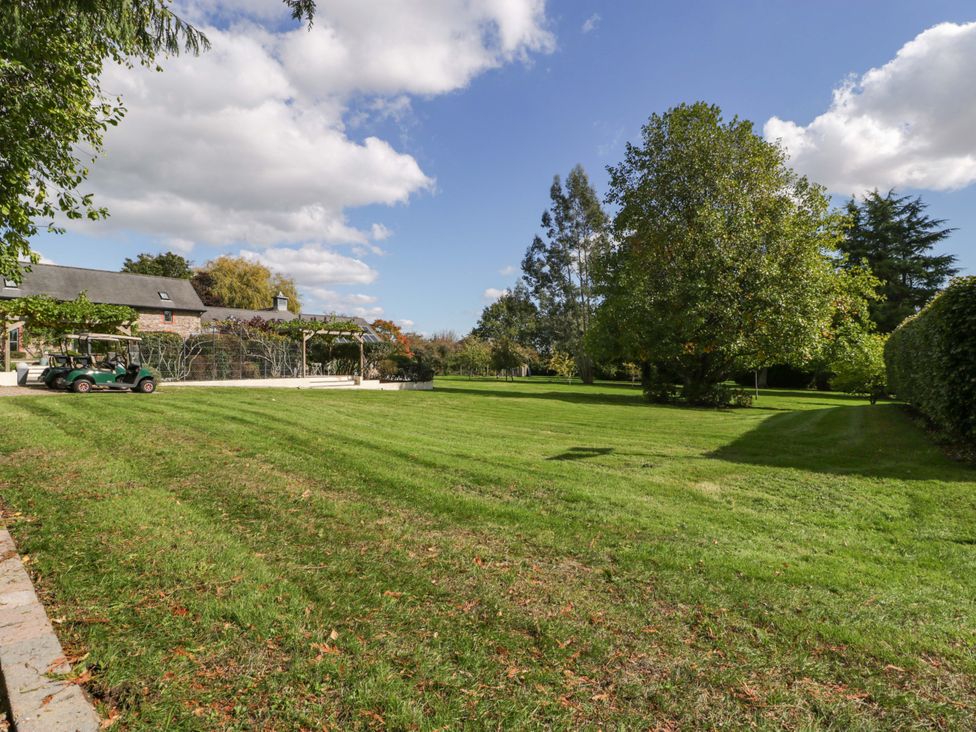 An outdoor area with a lawn and trees at Heathcliffe House in Castleton near Cardiff