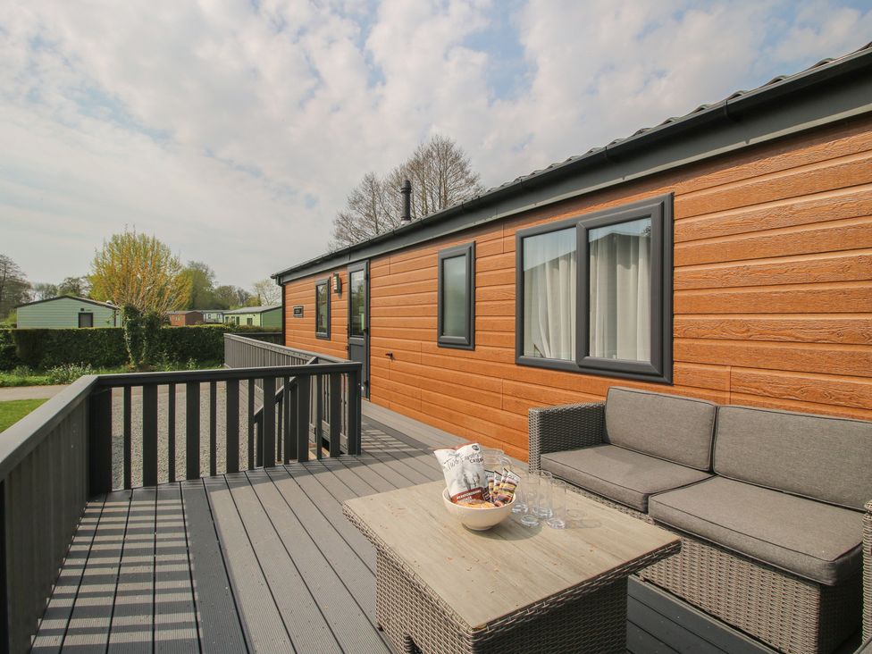 A deck area with seating and a table at Peony in Eardisland
