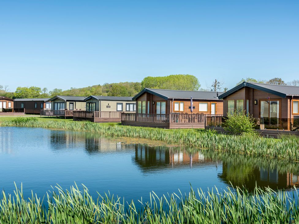 A row of cabins next to a lake at Peony Eardisland