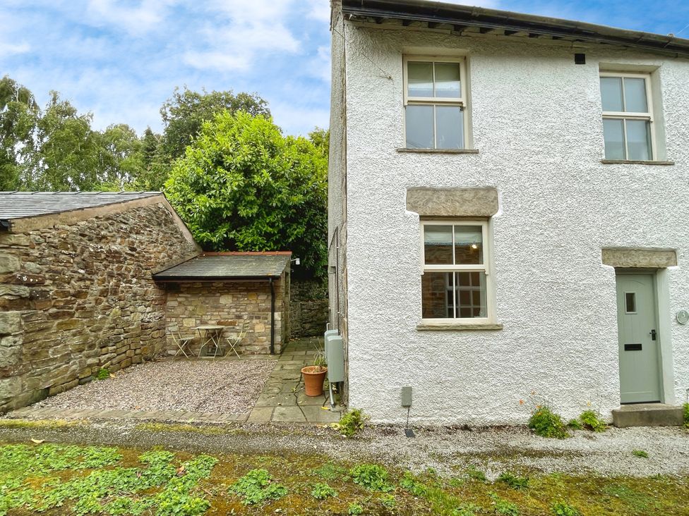 An outdoor area with a side view of a white house at 3 Chapel Square in Brookhouse near Caton