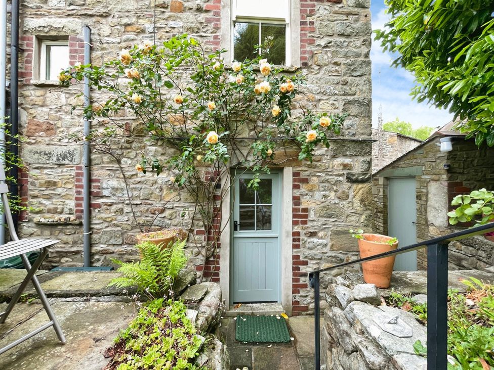 An outdoor area featuring a stone wall and flowers at 3 Chapel Square Brookhouse near Caton