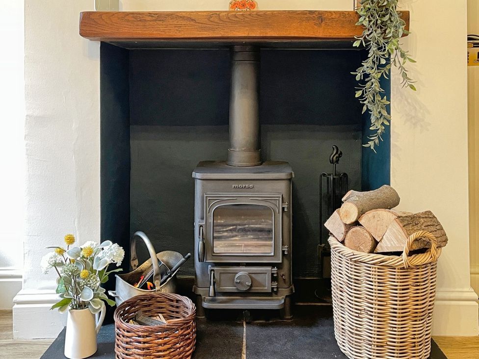 A living room featuring a stove and logs at 3 Chapel Square near Caton