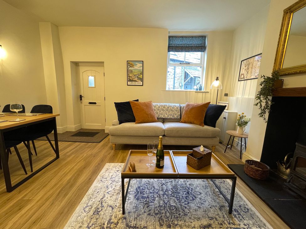 A living room with a sofa and dining area at 3 Chapel Square in Brookhouse near Caton