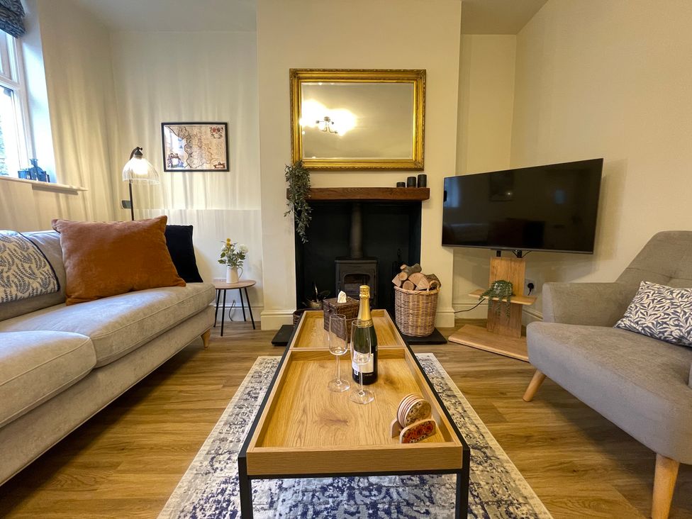 A living room with a sofa, table, and television at 3 Chapel Square in Brookhouse near Caton
