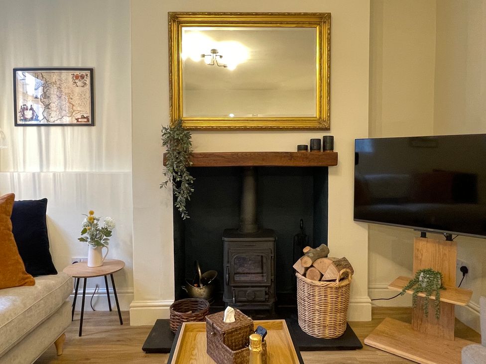 A living room with a fireplace and television at 3 Chapel Square in Brookhouse near Caton