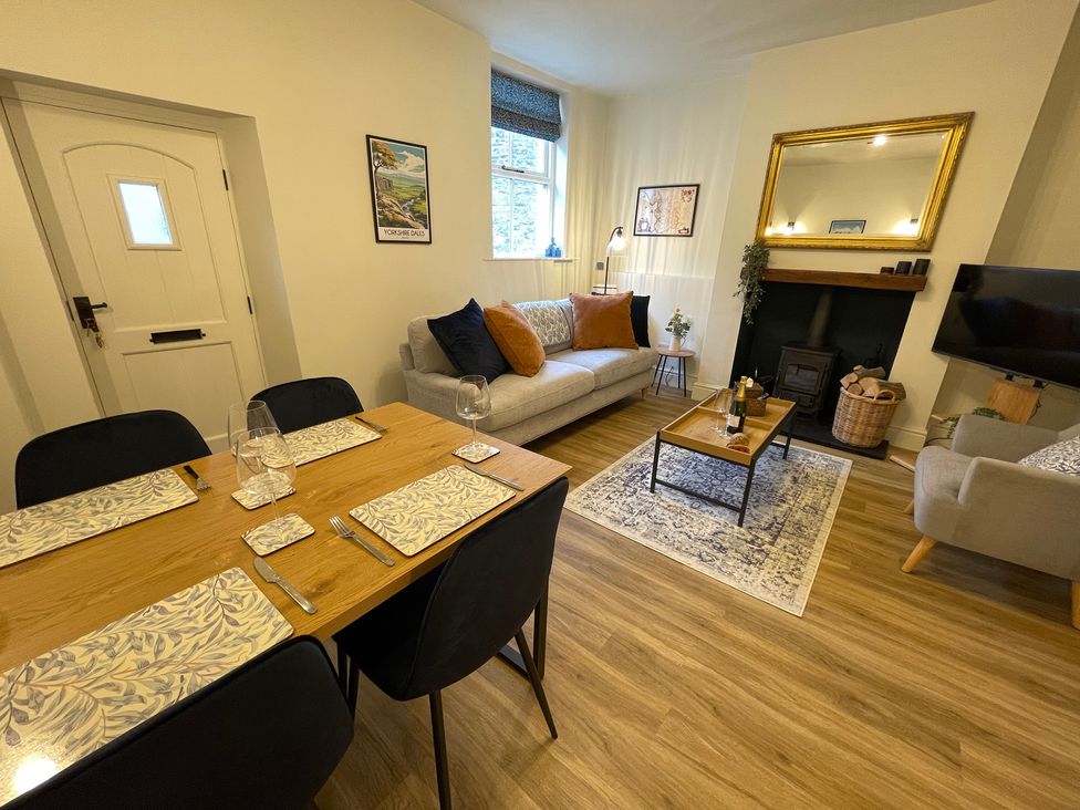 A living room with a dining table set and a couch at 3 Chapel Square in Brookhouse near Caton