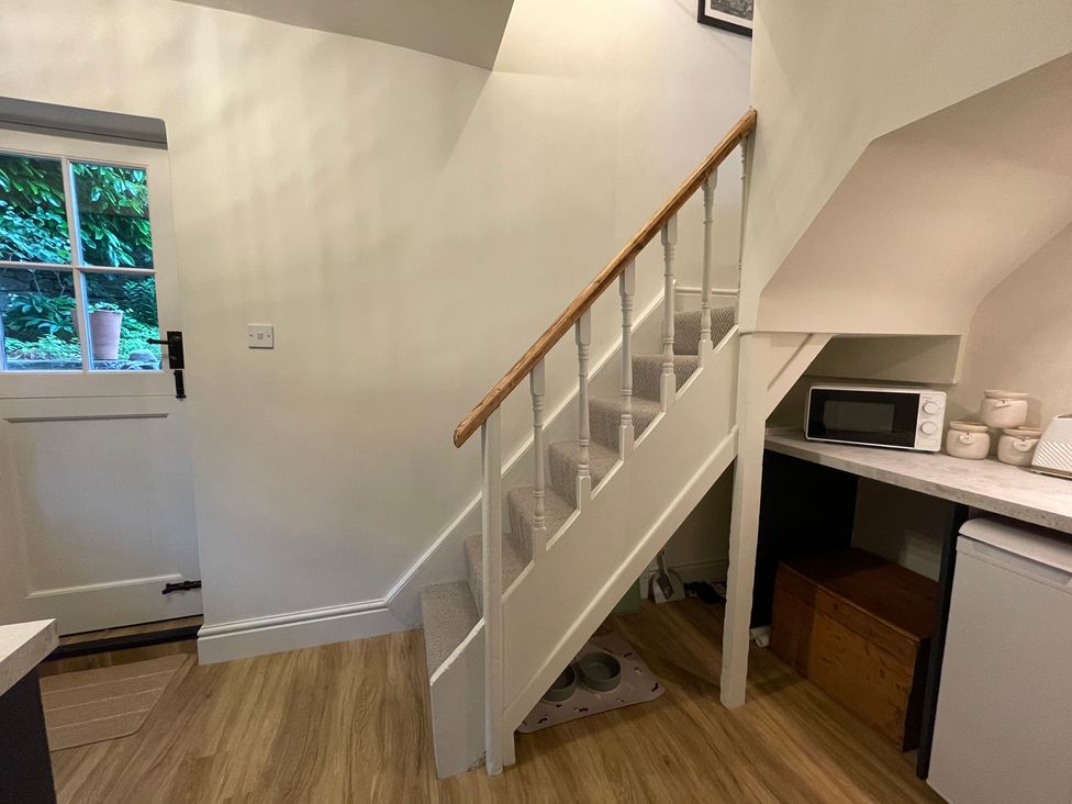 A hallway with a staircase and kitchen appliances at 3 Chapel Square Brookhouse near Caton