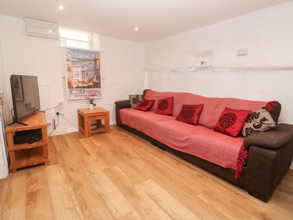A living room with a sofa and television at 23 Carncrows Street St Ives