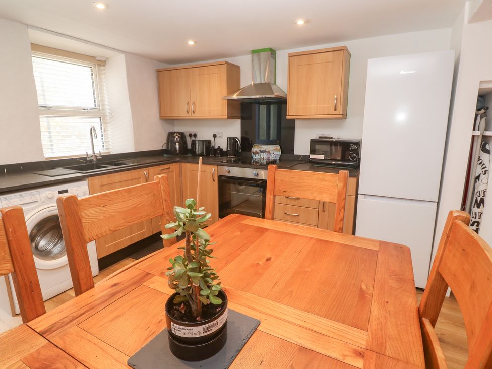 A kitchen with wooden furniture and appliances at 23 Carncrows Street St Ives