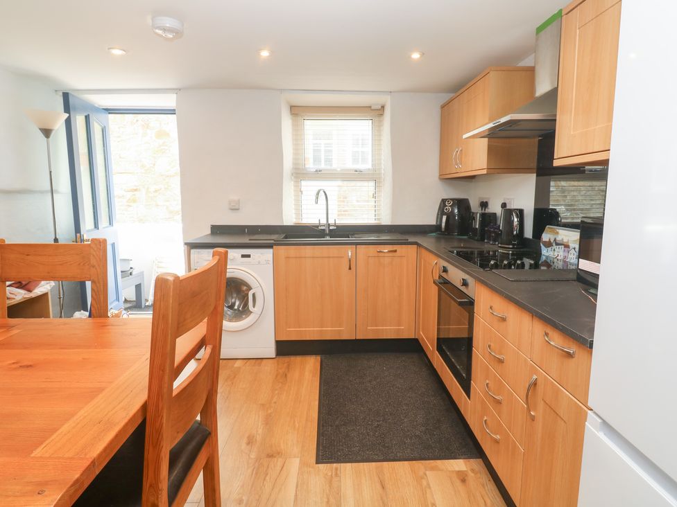 A kitchen with wooden cabinets and appliances at 23 Carncrows Street St Ives