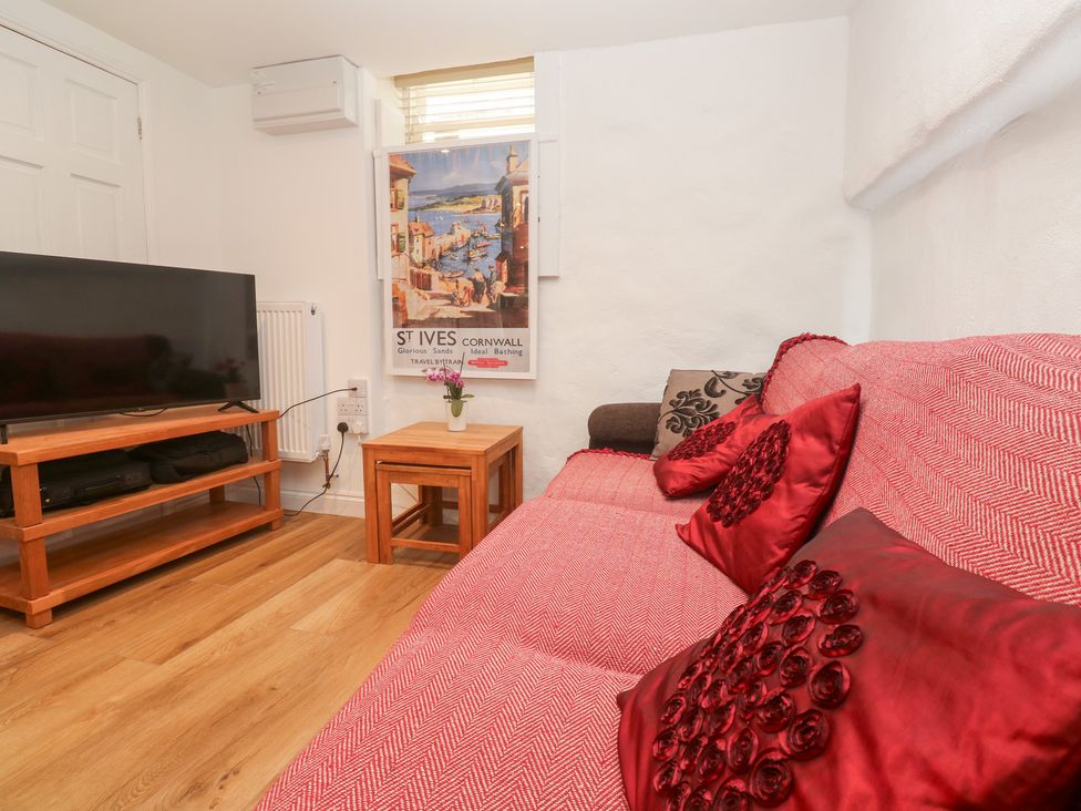A living room with a sofa and television at 23 Carncrows Street St Ives