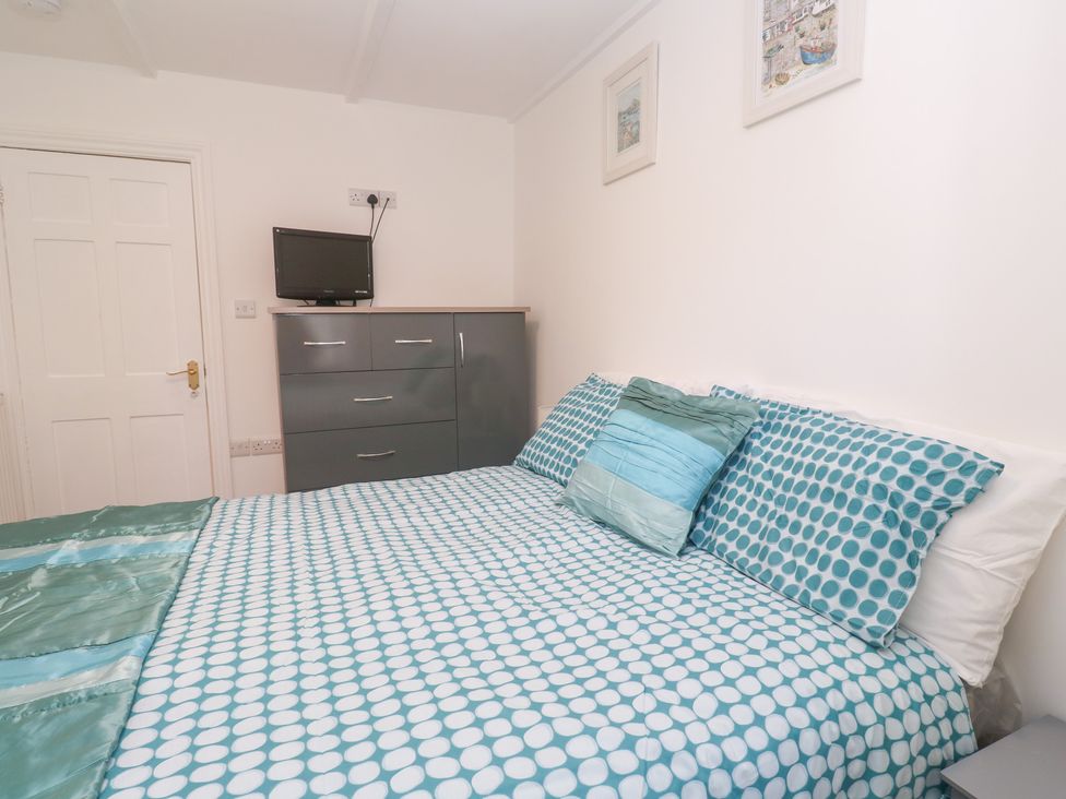 A bedroom with a bed and dresser at 23 Carncrows Street in St Ives