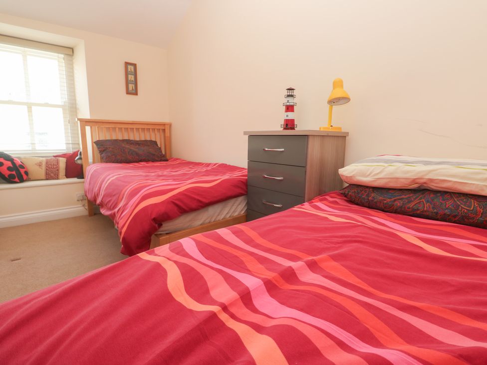 A bedroom with two beds and a bedside table at 23 Carncrows Street St Ives
