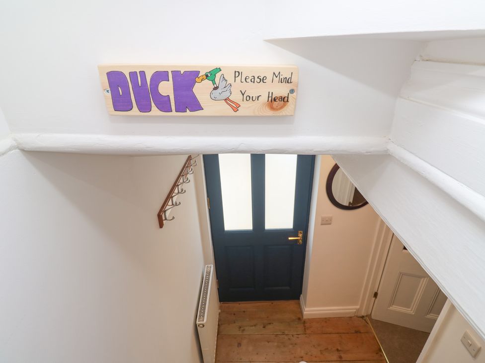 A staircase with a sign warning to mind your head at 23 Carncrows Street St Ives