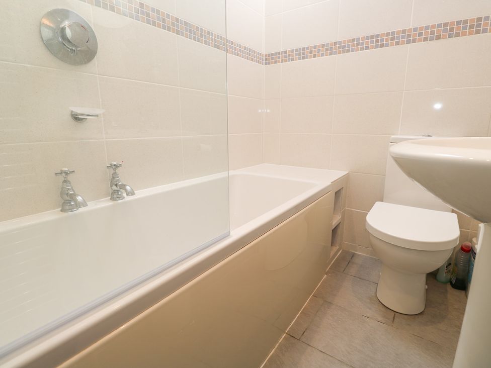 A bathroom with a bathtub, toilet, and sink at 23 Carncrows Street St Ives