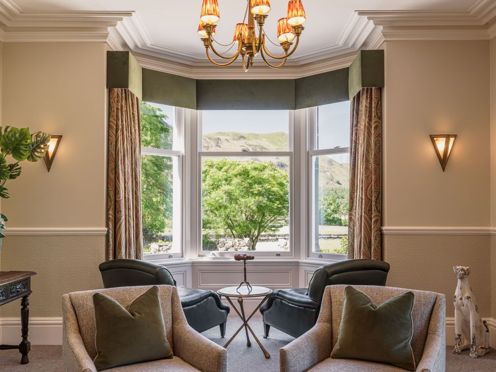 A living room with a chandelier and two armchairs at Leathes Head Country House Borrowdale near Keswick