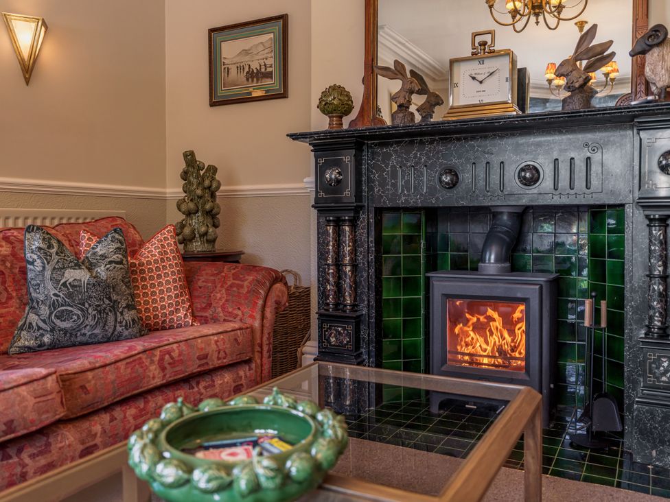 A living room with a fireplace and sofa at Leathes Head Country House in Borrowdale near Keswick