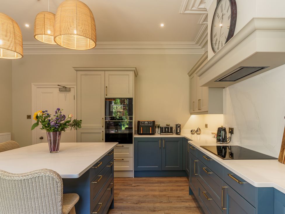 A kitchen with an island counter and flowers at Leathes Head Country House Borrowdale near Keswick