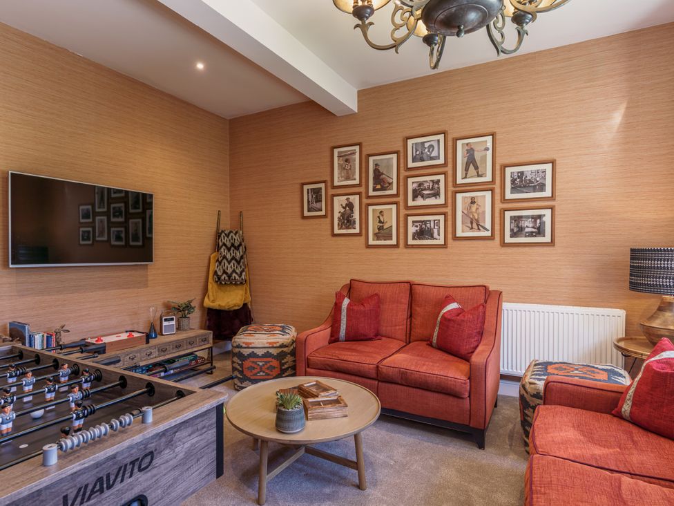 A living room with a foosball table and a television at Leathes Head Country House in Borrowdale near Keswick