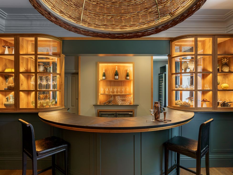 A bar area with a counter, shelves, and glassware at Leathes Head Country House in Borrowdale near Keswick