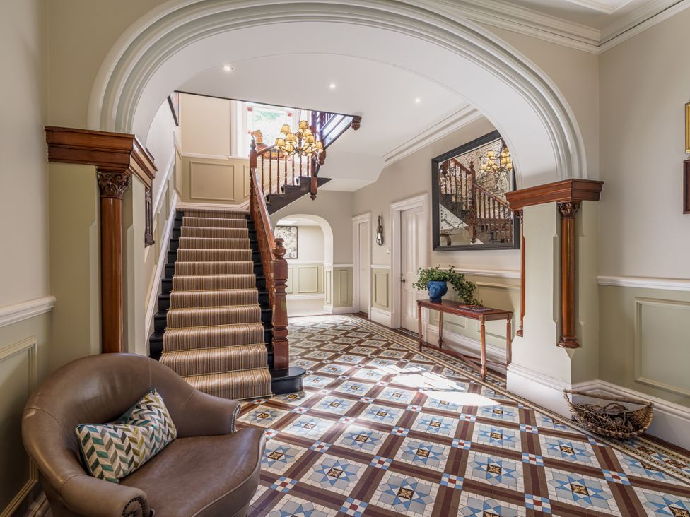 A hallway with a staircase and a decorative table at Leathes Head Country House Borrowdale near Keswick