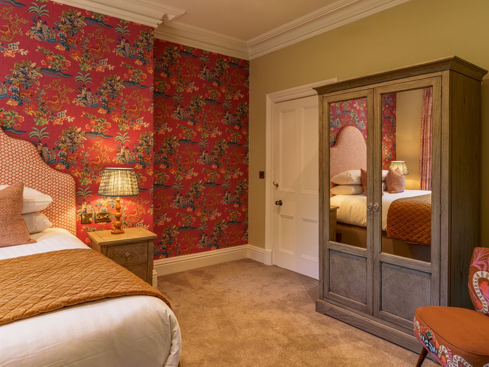 A bedroom with a bed and wardrobe at Leathes Head Country House in Borrowdale near Keswick