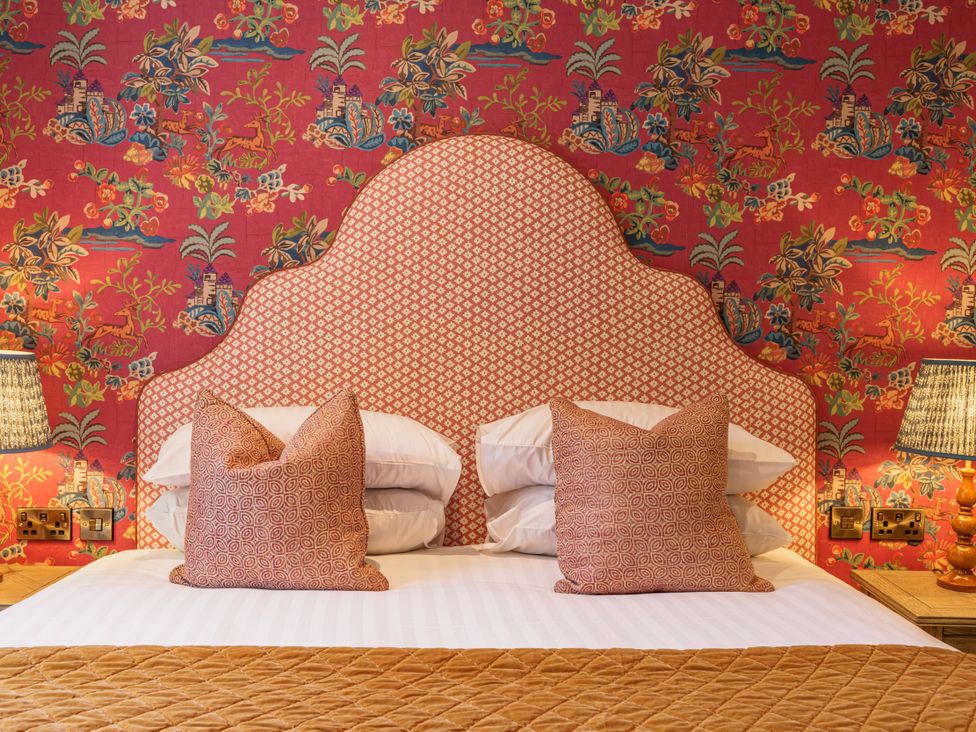 A bedroom with a patterned headboard and pillows at Leathes Head Country House in Borrowdale near Keswick