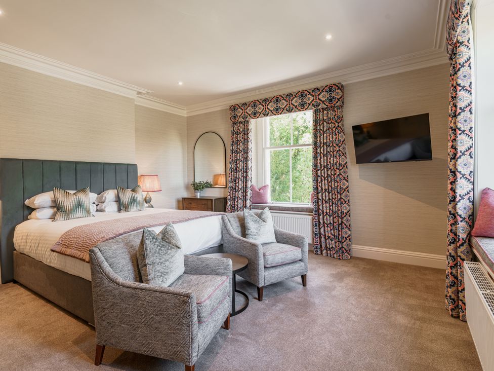 A bedroom with a bed and chairs at Leathes Head Country House Borrowdale near Keswick