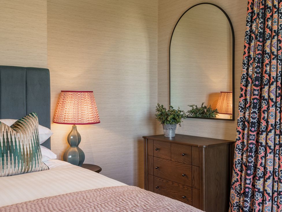 A bedroom with a bed and dresser at Leathes Head Country House in Borrowdale near Keswick
