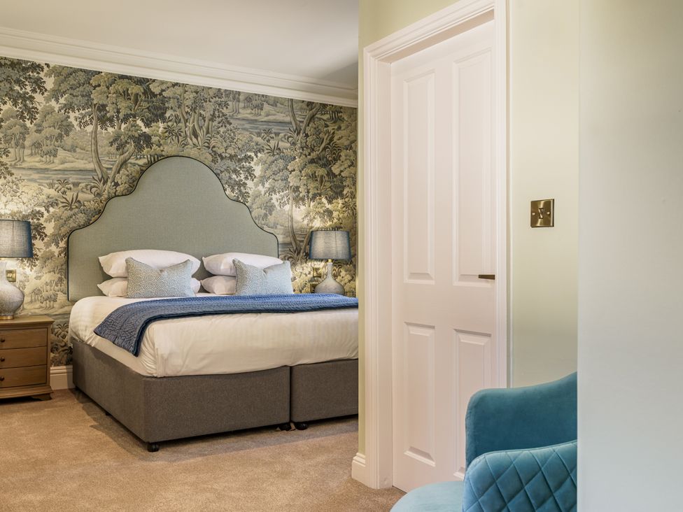 A bedroom with a bed and nightstands at Leathes Head Country House in Borrowdale near Keswick