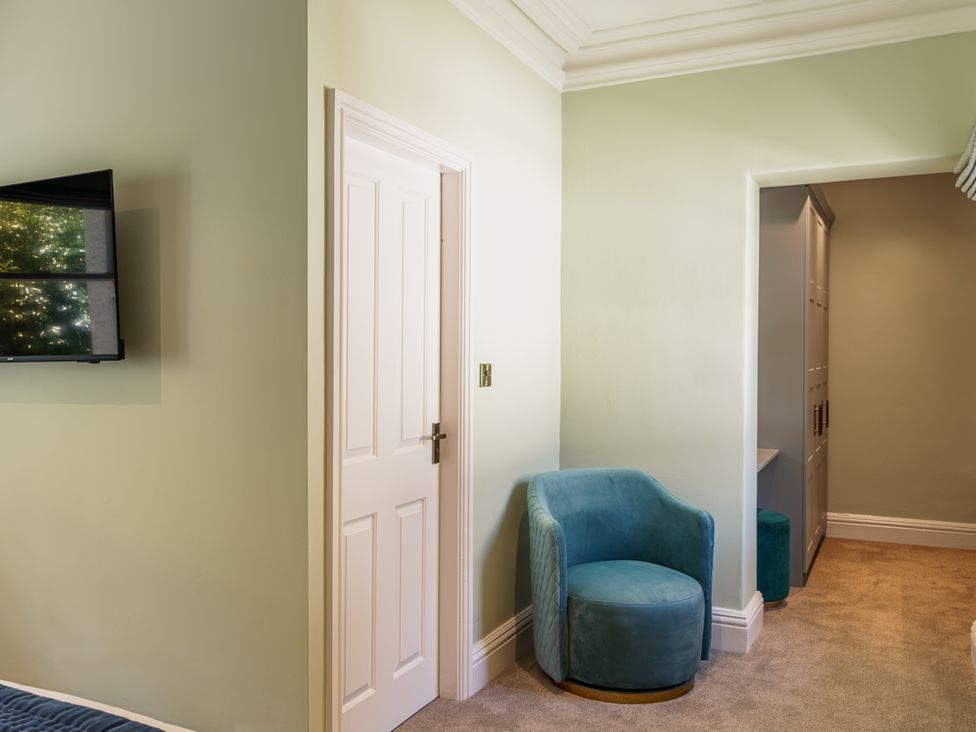 A bedroom with an armchair and television at Leathes Head Country House, Borrowdale near Keswick
