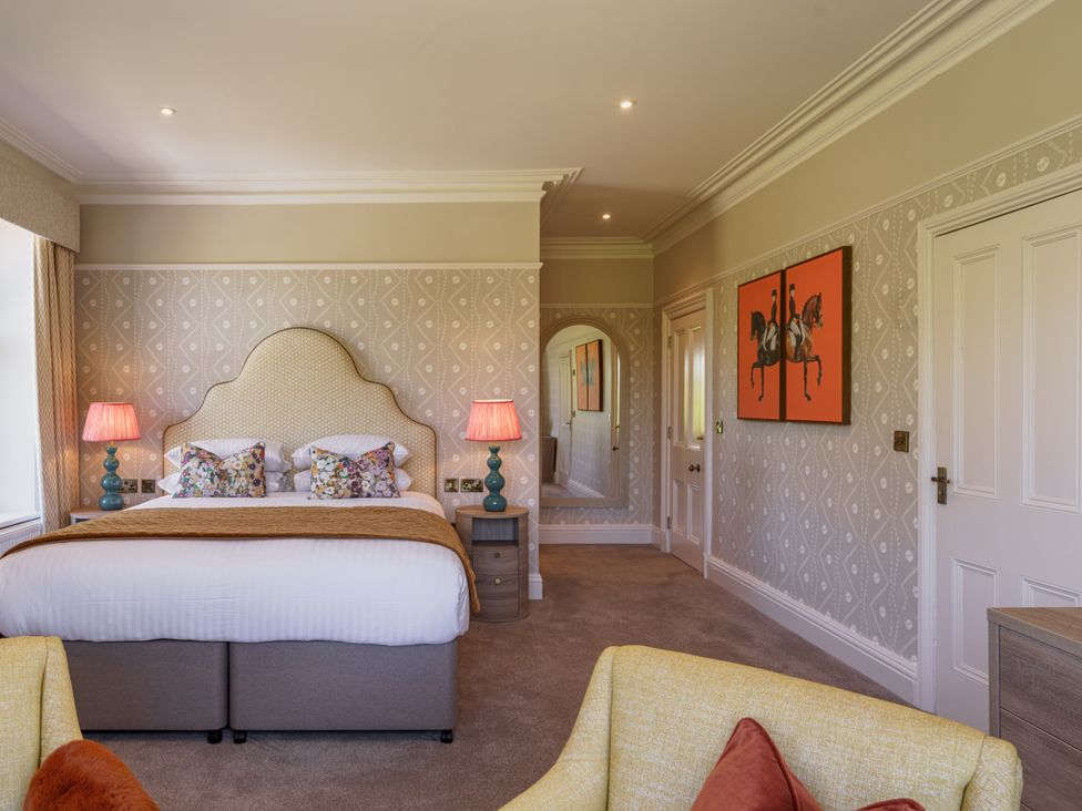 A bedroom with a bed, lamps, and wall art at Leathes Head Country House Borrowdale near Keswick