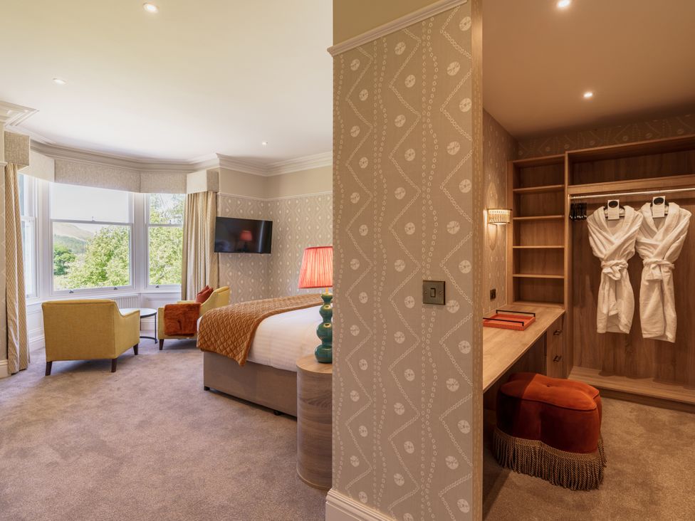 A bedroom with a bed and armchairs at Leathes Head Country House Borrowdale near Keswick