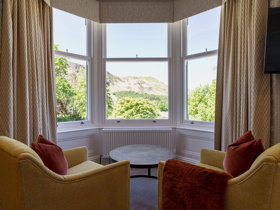 A sitting room with a view and furniture at Leathes Head Country House in Borrowdale near Keswick