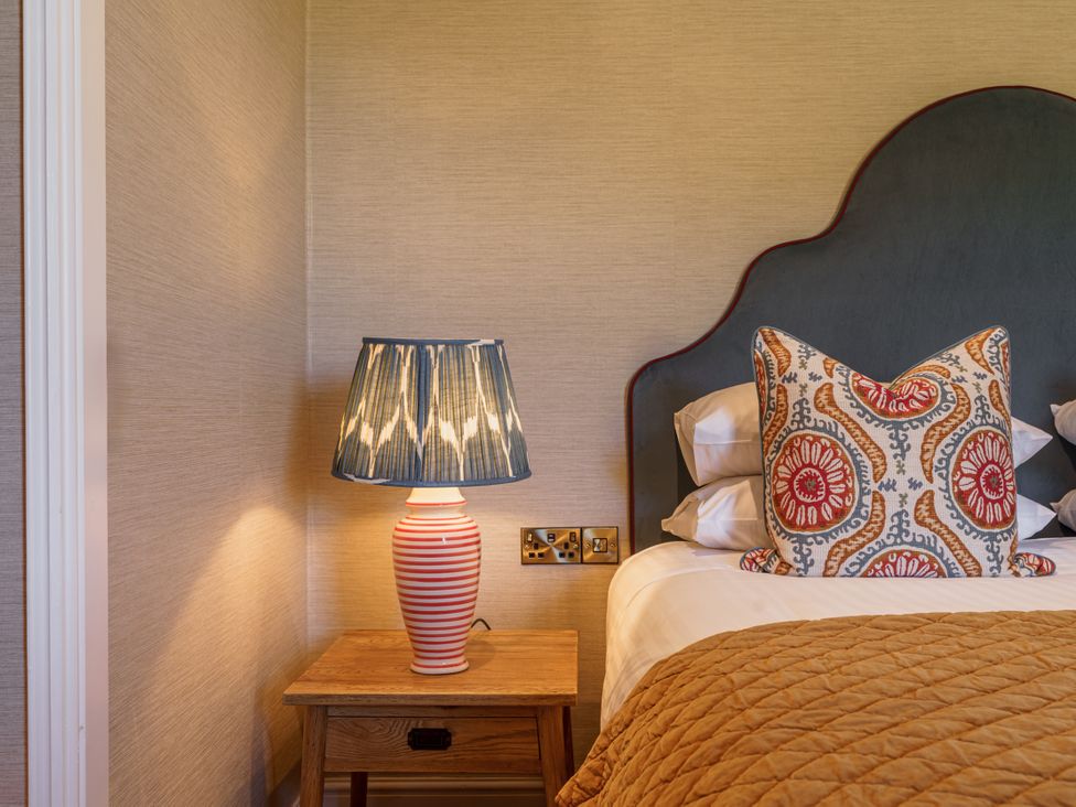 A bedroom with bedside table and lamp at Leathes Head Country House in Borrowdale near Keswick