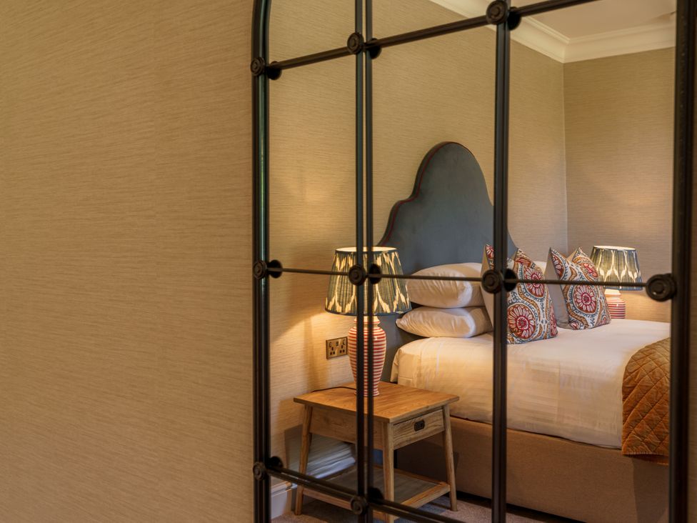 A bedroom with a bed, nightstand and lamps at Leathes Head Country House near Keswick
