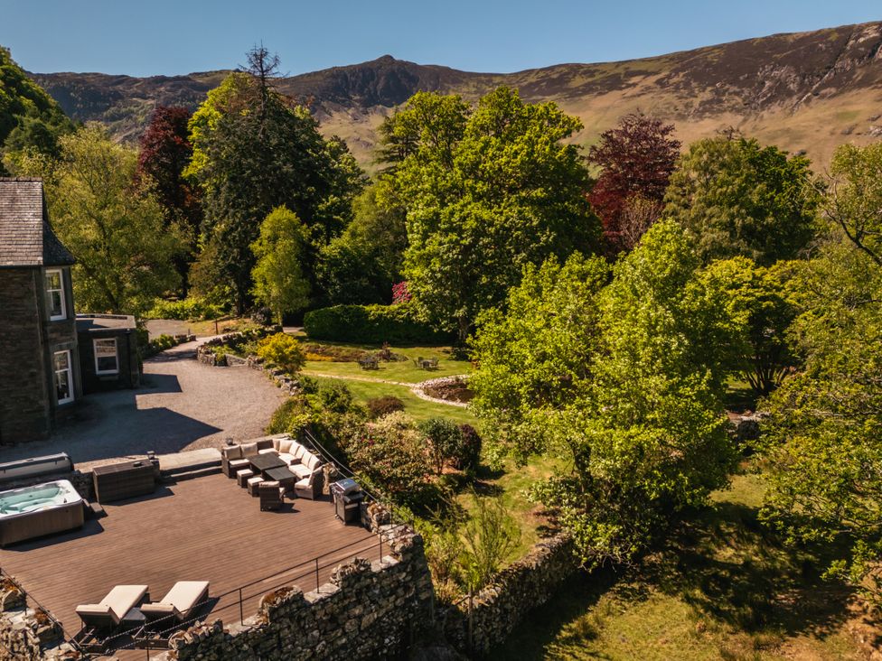 An outdoor seating area with a hot tub and trees at Leathes Head Country House, Borrowdale near Keswick