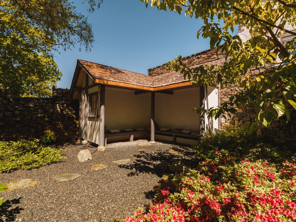 A outdoor shelter with benches in a garden at Leathes Head Country House Borrowdale near Keswick