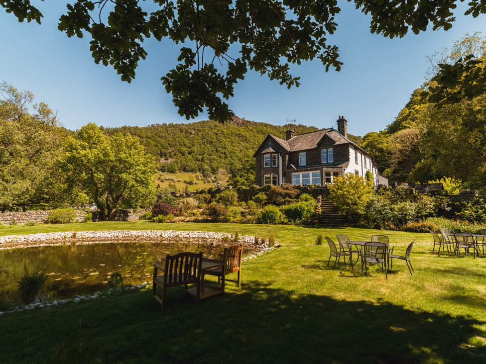 A garden with a house and pond at Leathes Head Country House in Borrowdale near Keswick